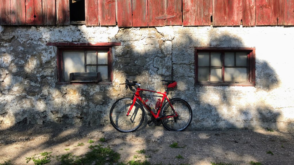 Photo of my bike against a red barn, my attempt at an artistic photo, inspired by GravelRoad.Ca's instagram account.