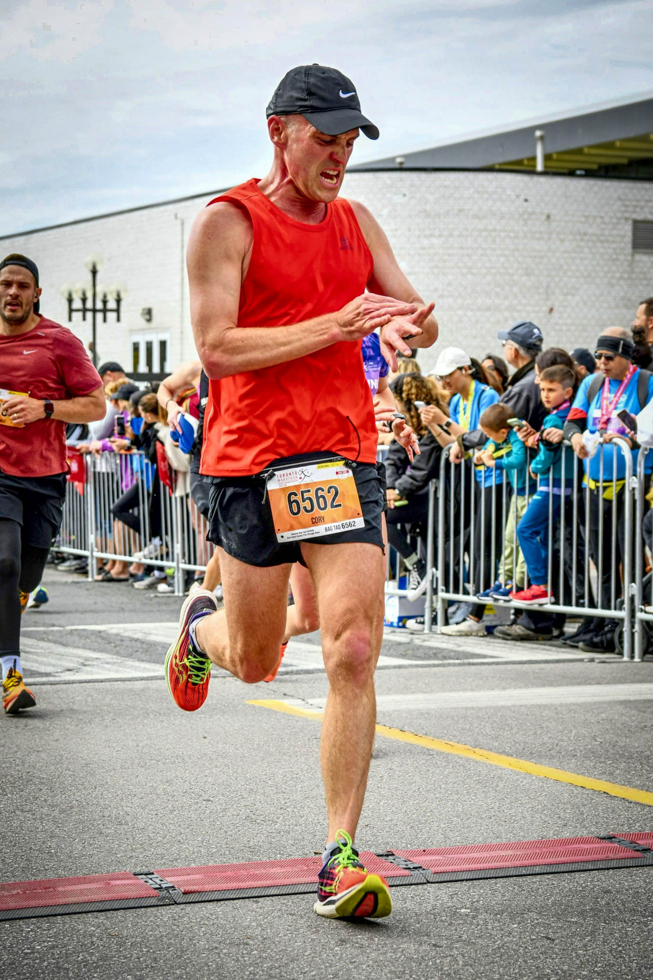 Tapping my Garmin at the end of the 2023 Toronto Half Marathon.